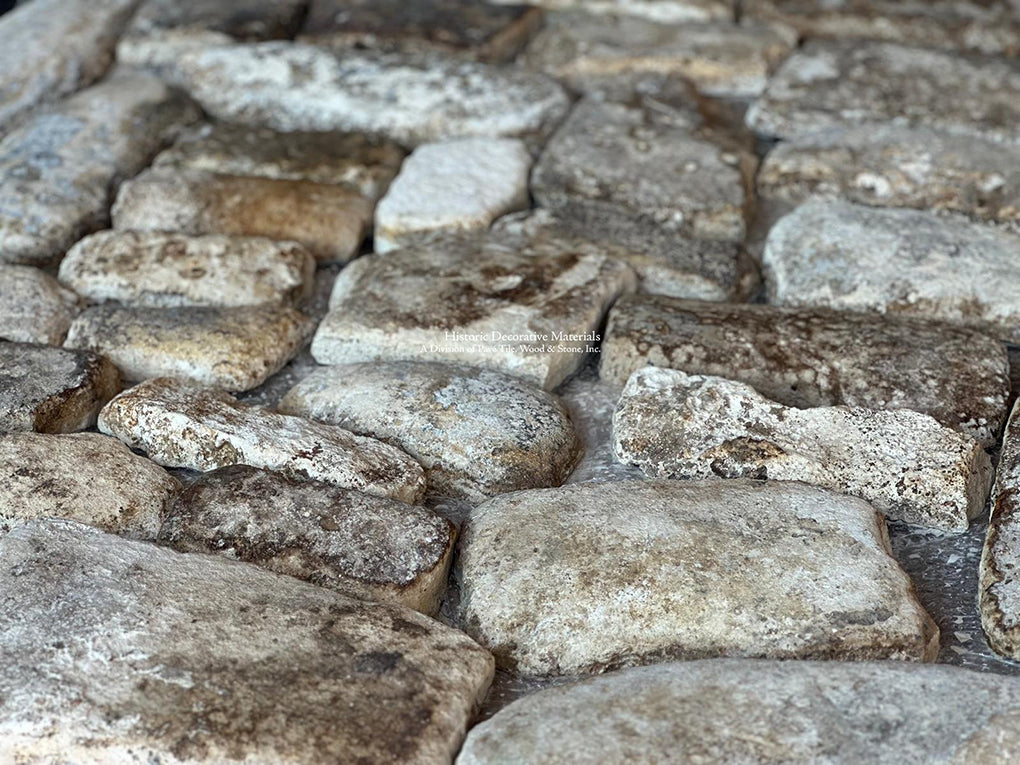 Patina arises on the surface of these antique French limestone cobblestones with centuries of wear. 