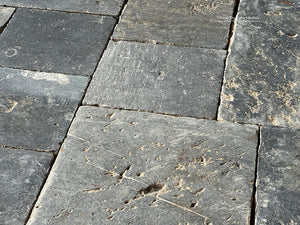 Install antique Belgian bluestone in a living space framing an antique French fireplace mantel for elegant authenticity. 