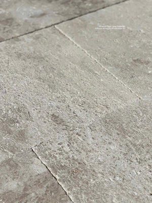 Antique French limestone floors with beautifully aged details create an elegant floor installation. 