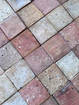 Antique French clay floor tiles in faded rose, warm buff and creamy beige paired with limestone, plaster and aged oak