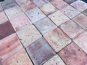 Antique handmade French terra cotta floor tile with worn historic surface