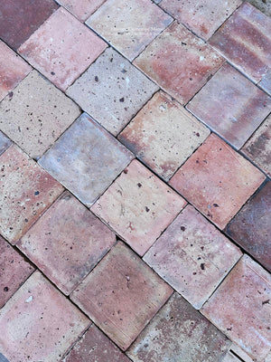 Antique French clay floor tiles with irregular edges pits and historic wear
