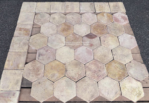 Antique French terra cotta hexagon flooring with worn surfaces, softened edges and subtle ochre mineral variations.
