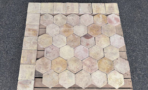 Antique French terra cotta kitchen floor tiles with muted ochre, pale apricot and cream tones and worn historic patina.