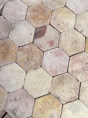 Authentic antique French terra cotta flooring with warm mineral colors and traditional hexagonal tiles for country house interiors.