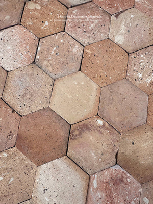 French country farmhouse hexagon floor tiles in warm orange ochre and peach tones