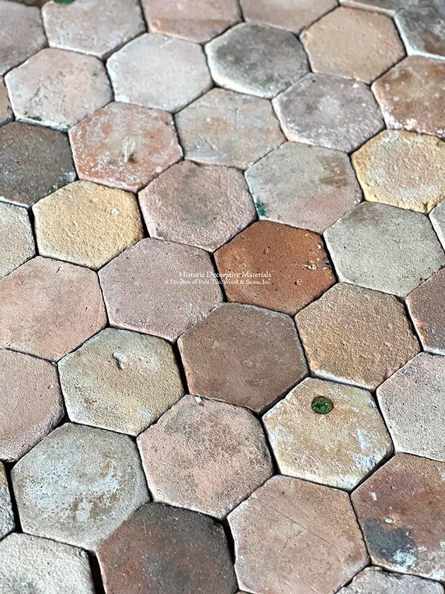 Small cobblestone French reclaimed terra cotta tile hexagons create historic, geometric patterns for a kitchen floor.