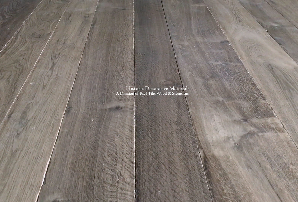 Beautiful antiqued French oak floor in warm brown with gray undertones enriches an interior with historic warmth.