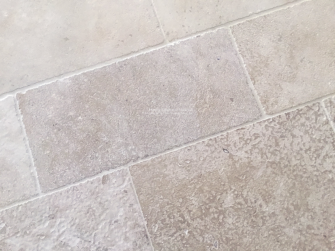 Antiqued French limestone flooring in warm neutrals is a beautiful anchor to fine interiors.