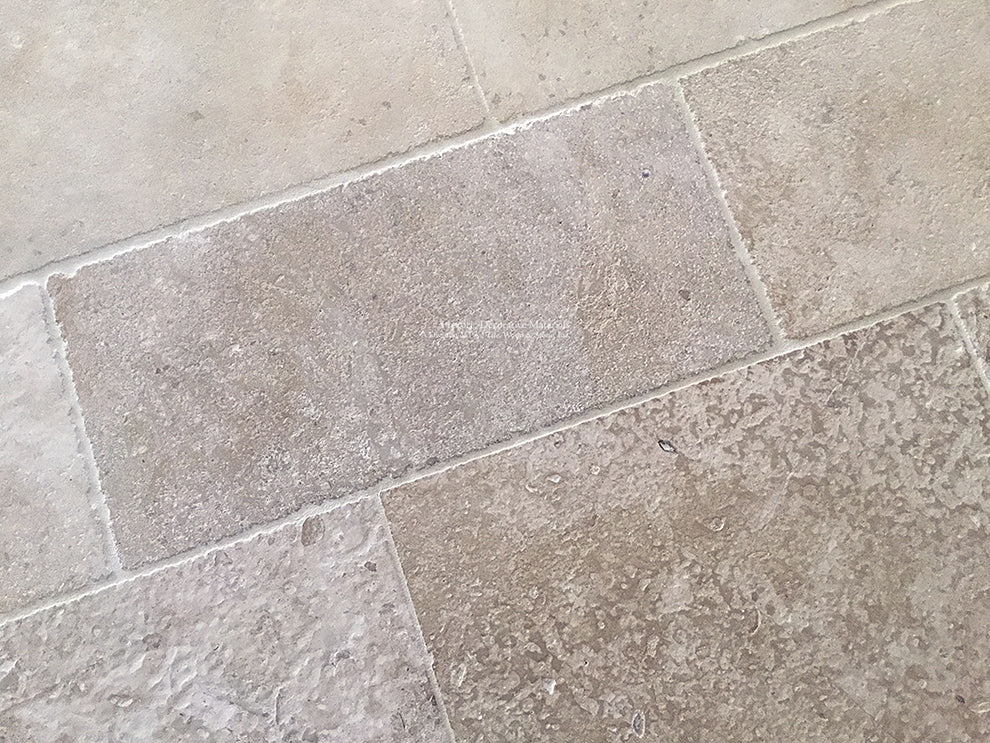 Antiqued French limestone flooring in warm neutrals is a beautiful anchor to fine interiors.