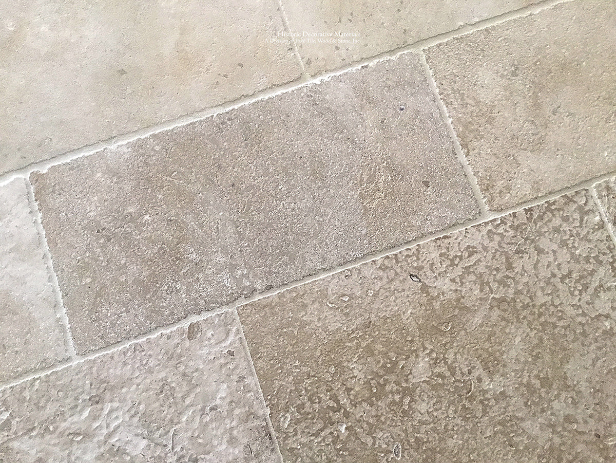 Antiqued French limestone flooring in warm neutrals is a beautiful anchor to fine interiors.