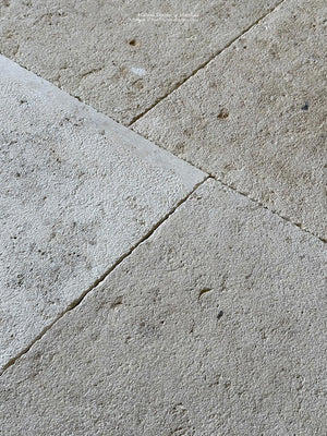 Antiqued French limestone floors in grand dalle pavers are handsome interior tiles.
