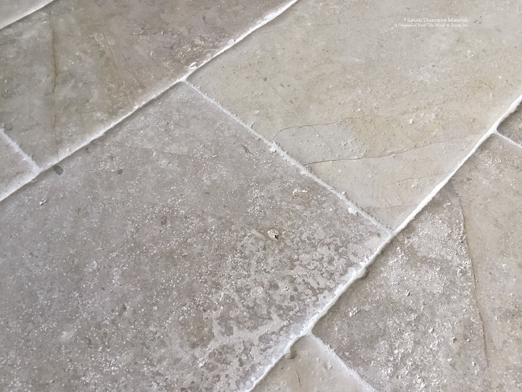 Antiqued French Limestone Flooring | Reclaimed surface patina for historic interior design.