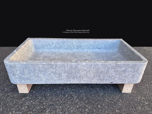 Antiqued French limestone sink with weathered gray stone texture