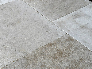 Hand-hammered gray and cream antique French limestone floors add historic texture to a room.