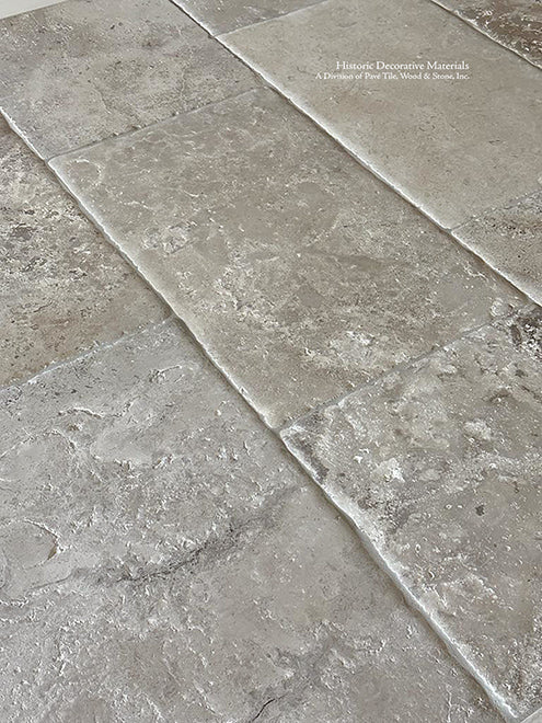 Antiqued French Limestone Floors in cream and gray hues are a masterful approach to dining and kitchen floors.