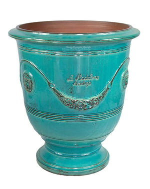 Anduze bell-shaped terra cotta vase with garlands in turquoise brings a water element aesthetic into a decorative garden.