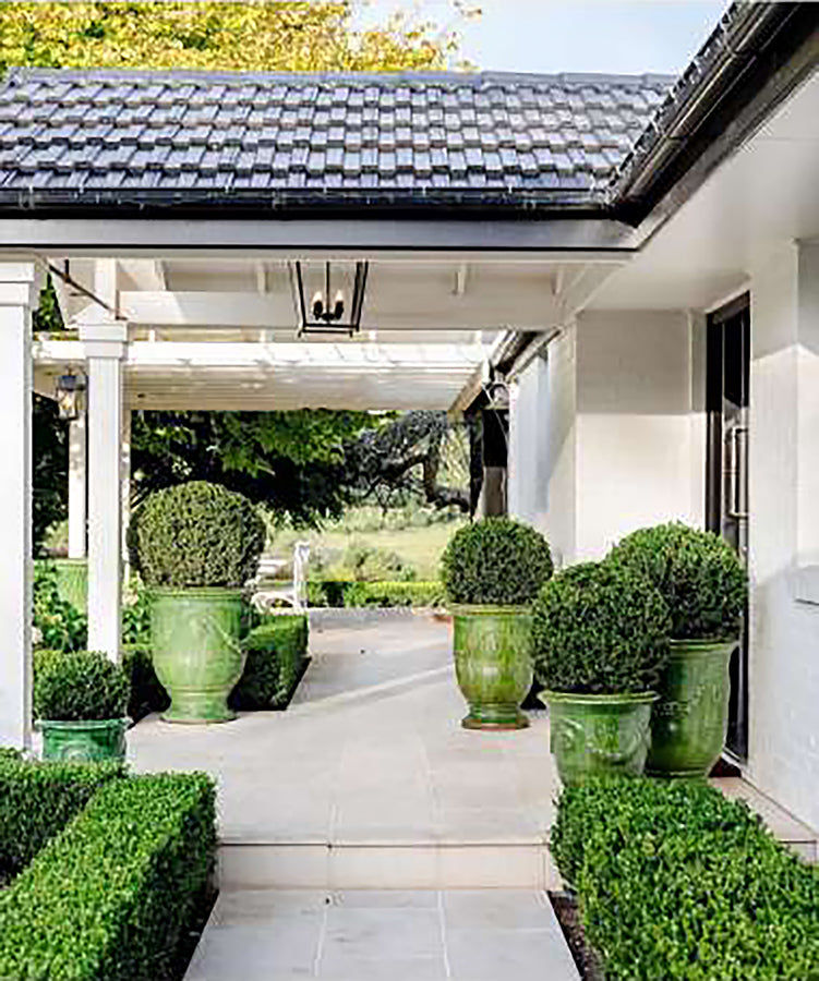 A contemporary home's entryway is softened displaying antiqued terra cotta vases from Anduze Provence.